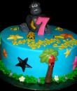 Gorilla Birthday Cake. Blue buttercream iced, round decorated with stars, flowers, trees, bananas, parrots and a gorilla. Everything on this cake is edible. (Serves 8-80 party slices.) 