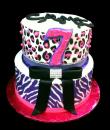 Rhinestone Bow Animal 7th Birthday cake,  White buttercream iced, 2 round tiers decorated with rhinestones, bow, pearls, animal print edible wrap, everything on this cake is EDIBLE except the rhinestones. (Serves 28-55 party slices)