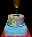 Martini Glass Birthday cake,  Blue and purple buttercream iced, 2 tiers, one round, one square, decorated with circles, squares, and random shapes. Everything on this cake is EDIBLE.  (Martini glass was provided by client). 