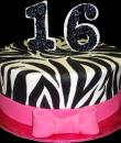 Zebra Striped 16th Birthday Cake,  White buttercream iced, round decorated with fondant zebra stripes and a pink bow.  Everything on this cake is EDIBLE.  (Serves 8-80 party slices)